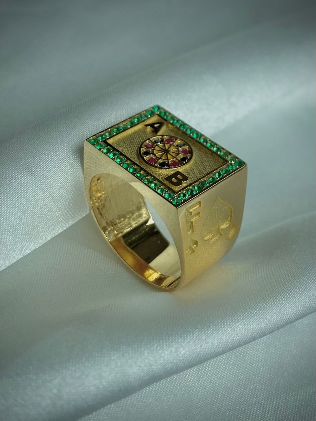 ANILLO RULETA INICIALES 0,40 CTS ESMERALDAS, 0,06 CTS DIAMANTES NEGROS, 0,06 RUBIES/ ORO AMARILLO 10,46GR