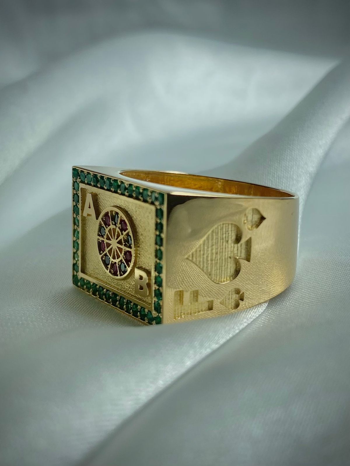 ANILLO RULETA INICIALES 0,40 CTS ESMERALDAS, 0,06 CTS DIAMANTES NEGROS, 0,06 RUBIES/ ORO AMARILLO 10,46GR
